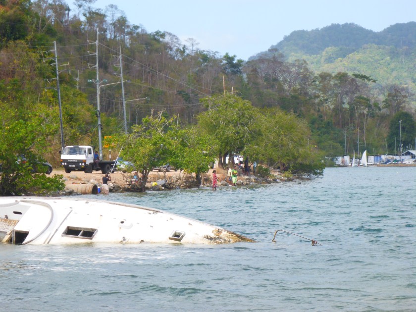Plastic and sunken sailboat mar Trinidad beach. environmental activism.