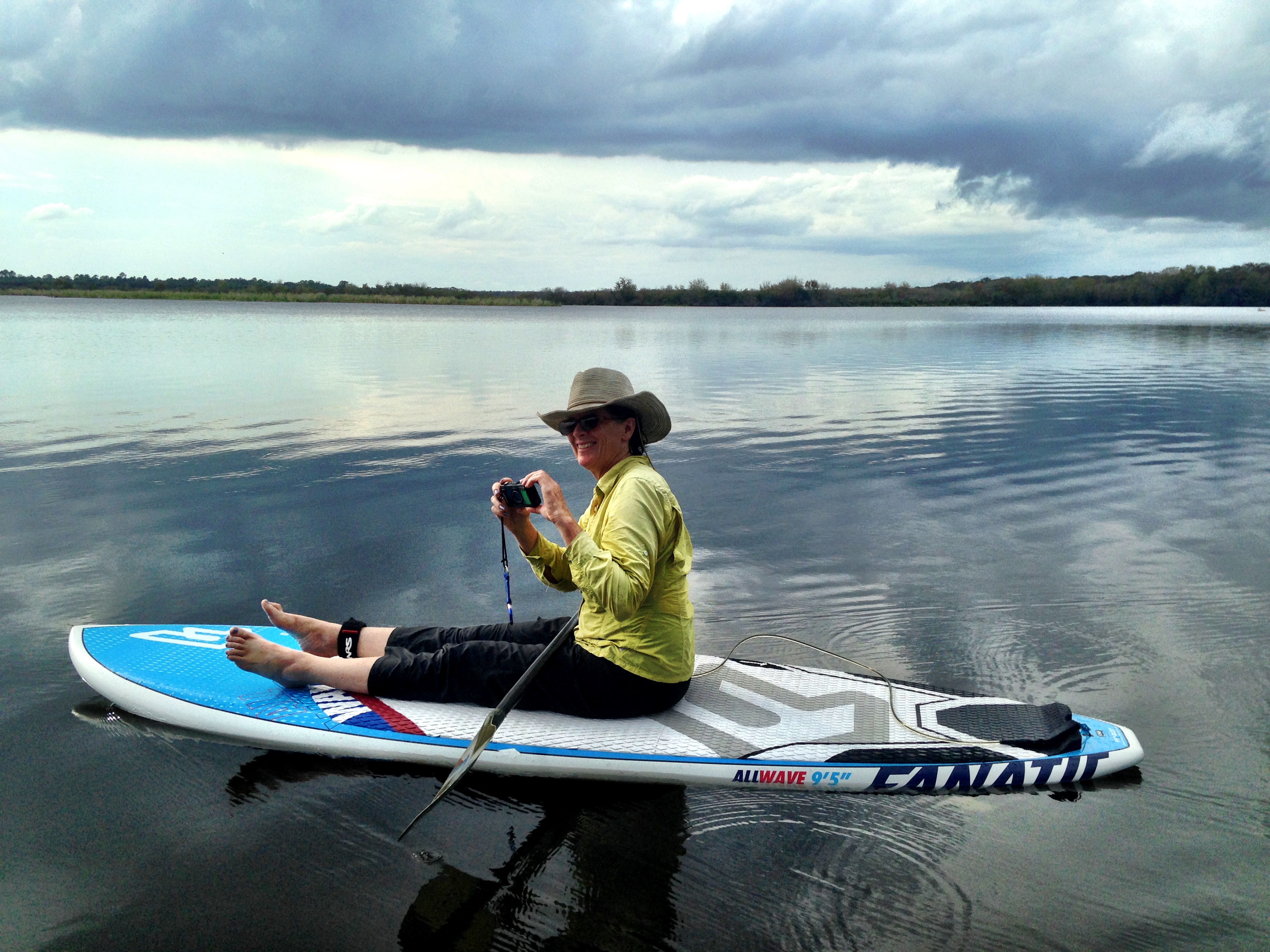 floating on a paddleboard under cloudy skies in DeLeon Springs State Park, Florida